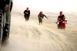 Bedouin waited for gifts to be thrown from the passing convoy of US Marines in the southern Iraqi desert